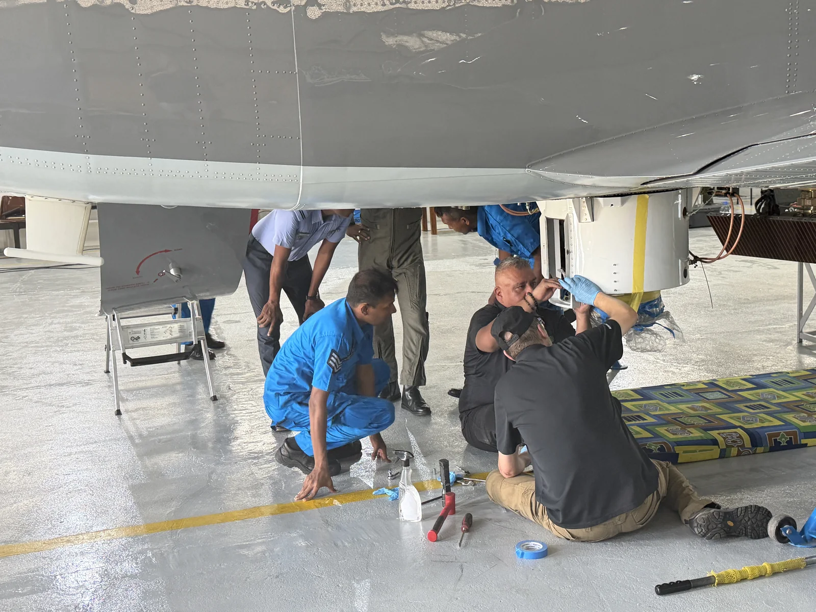 Technicians working together at an aircraft mission-system installation